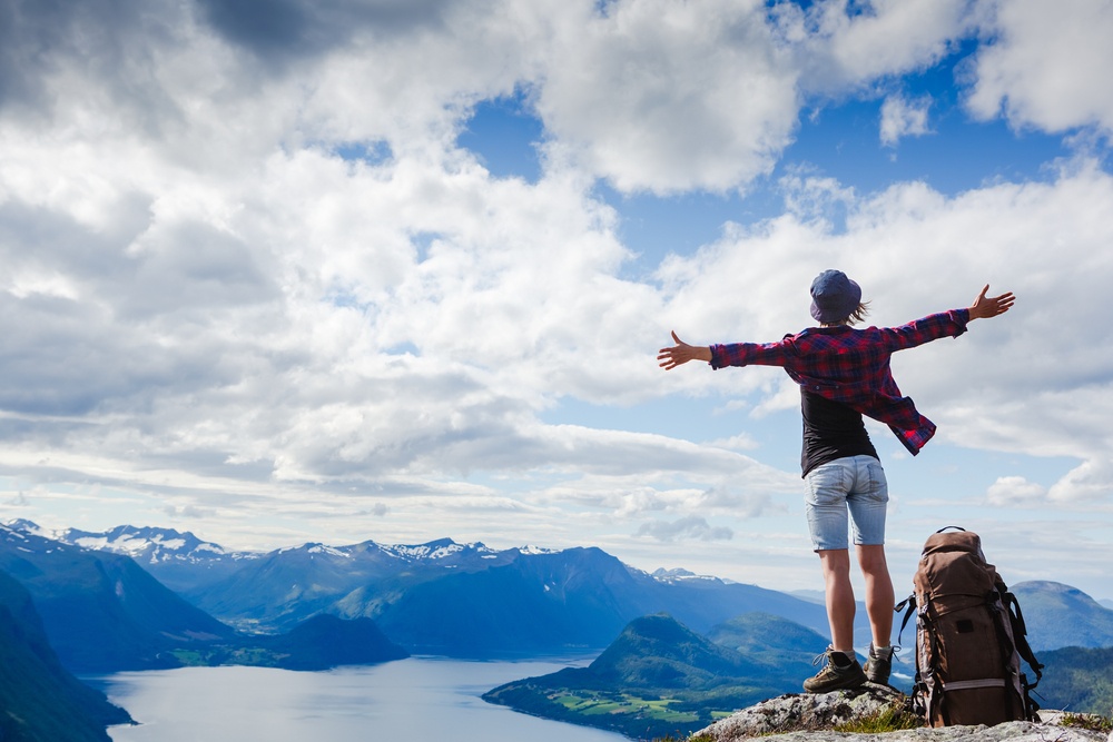 Girl standing on mountaintop with arms wide open